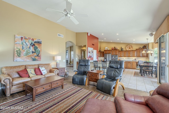 living room with visible vents, arched walkways, ceiling fan, high vaulted ceiling, and recessed lighting