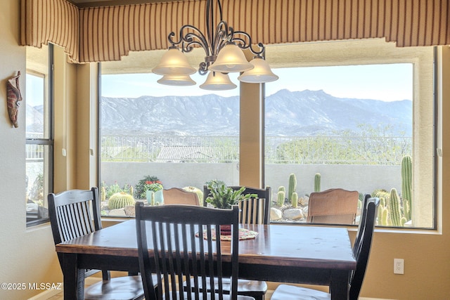 dining space with a wealth of natural light, a mountain view, and an inviting chandelier