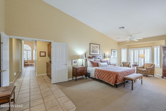 bedroom featuring light carpet, visible vents, arched walkways, and light tile patterned flooring