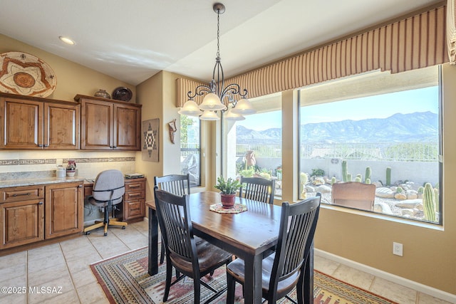 dining room featuring light tile patterned flooring, vaulted ceiling, a mountain view, a chandelier, and baseboards