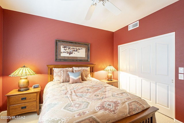 carpeted bedroom with visible vents and a ceiling fan