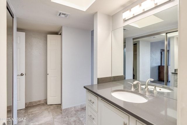 bathroom with vanity, visible vents, and baseboards