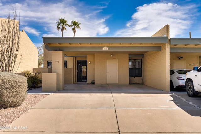 view of front of house with driveway, an attached carport, and brick siding