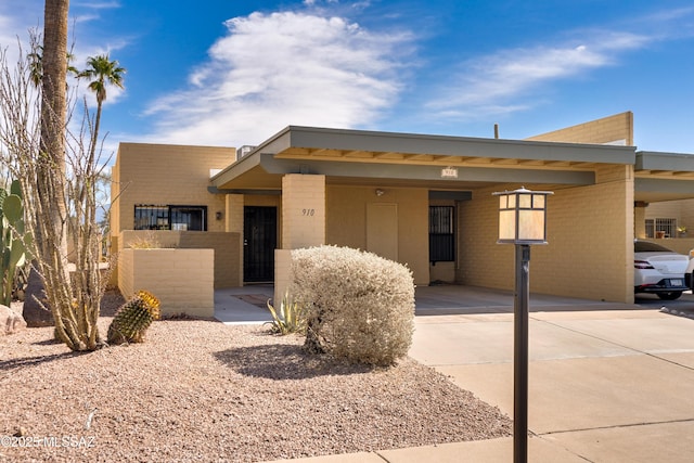 view of front of home featuring a carport, concrete driveway, and brick siding