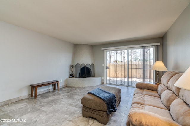 living area featuring a large fireplace and baseboards