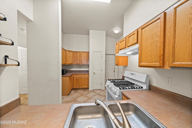 kitchen featuring sink, gas range gas stove, and light tile patterned flooring