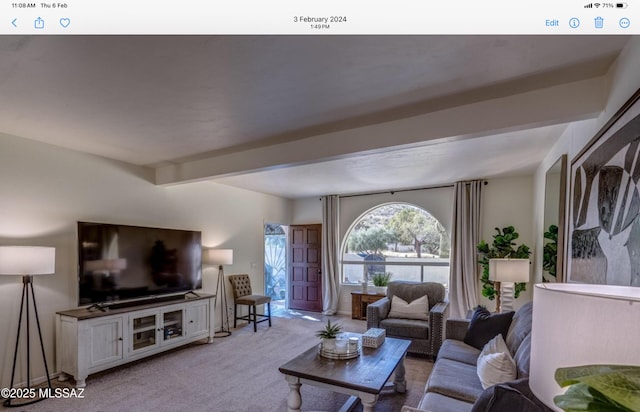 living room with beamed ceiling and light carpet