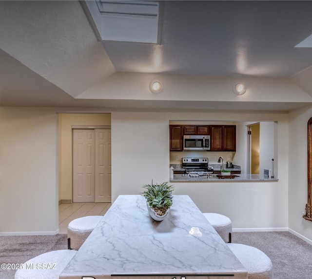 dining area featuring sink, vaulted ceiling, and light colored carpet