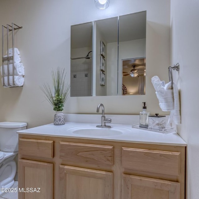 bathroom with vanity, ceiling fan, a shower, and toilet