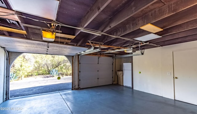 garage with a garage door opener and white fridge