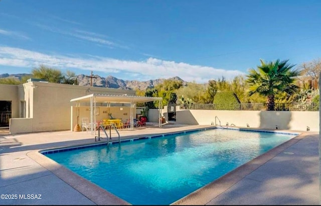 view of swimming pool featuring a mountain view and a patio