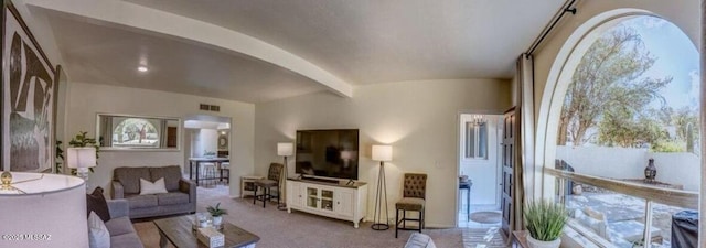 living room with beamed ceiling and light carpet