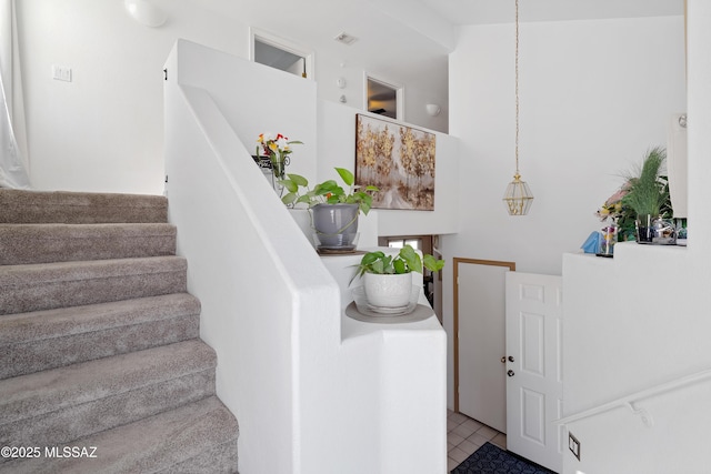 staircase featuring tile patterned flooring