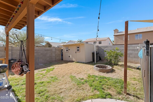 view of yard featuring an outbuilding and an outdoor fire pit