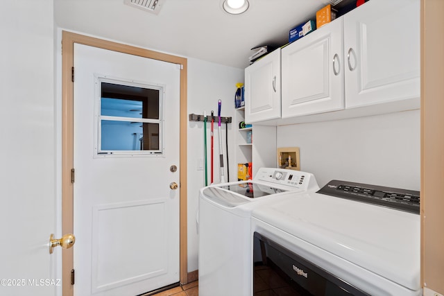 clothes washing area featuring cabinets and independent washer and dryer