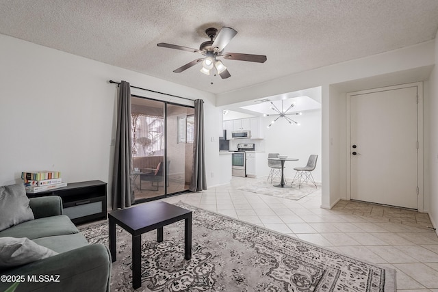 living room featuring light tile patterned flooring, ceiling fan with notable chandelier, and a textured ceiling