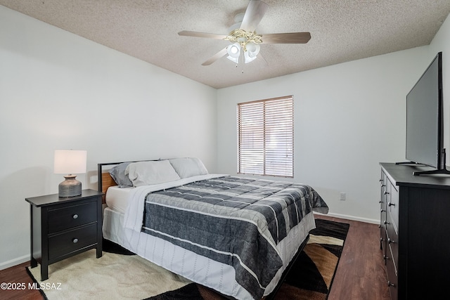 bedroom with ceiling fan, dark wood-type flooring, and a textured ceiling