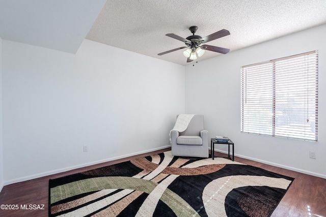 sitting room featuring ceiling fan, a textured ceiling, and dark hardwood / wood-style flooring