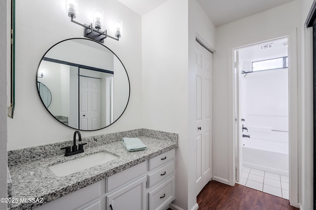 bathroom featuring hardwood / wood-style flooring, vanity, and shower / tub combination