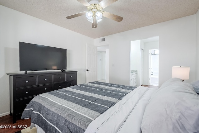 bedroom with hardwood / wood-style flooring, ceiling fan, connected bathroom, and a textured ceiling