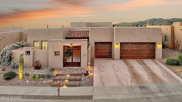 pueblo-style house featuring a mountain view and a garage