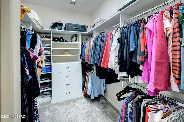 walk in closet with light colored carpet