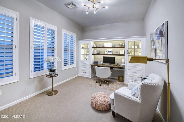 carpeted home office featuring built in desk and an inviting chandelier