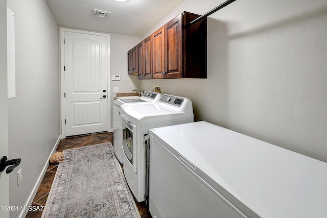 laundry room featuring cabinets and washer and dryer