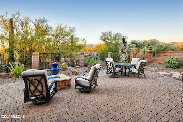 patio terrace at dusk featuring an outdoor fire pit