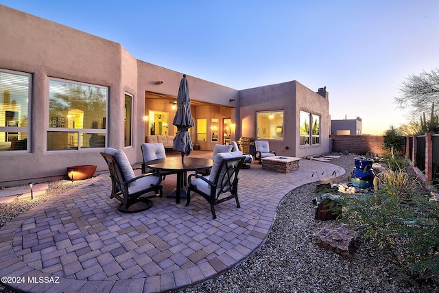 patio terrace at dusk featuring an outdoor fire pit