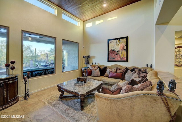 living room with a high ceiling, light tile patterned flooring, and wood ceiling