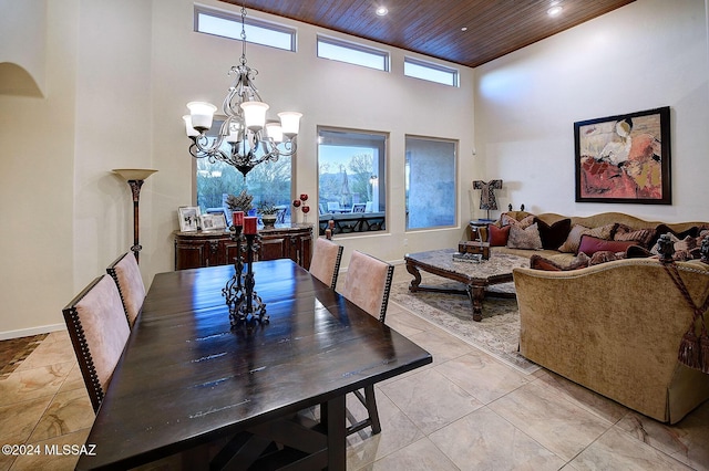 dining area featuring an inviting chandelier, wooden ceiling, and a high ceiling