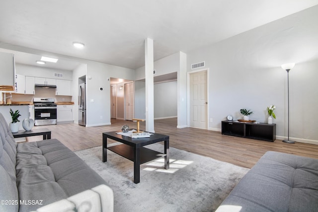 living room with sink and light wood-type flooring