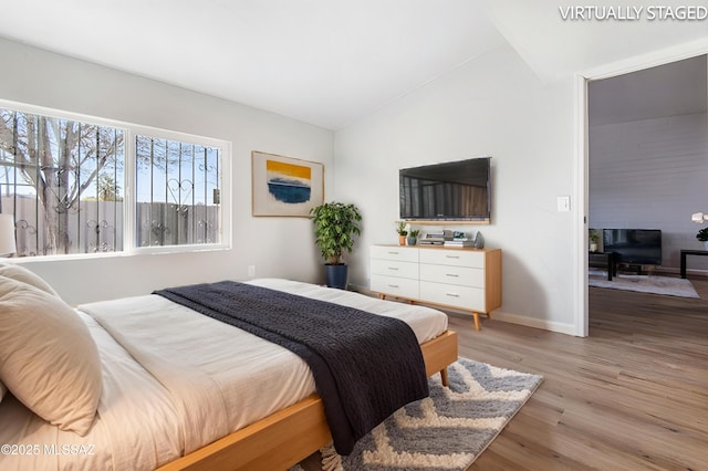 bedroom featuring hardwood / wood-style flooring and vaulted ceiling