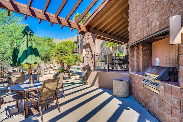 view of patio / terrace featuring area for grilling, a pergola, and exterior kitchen