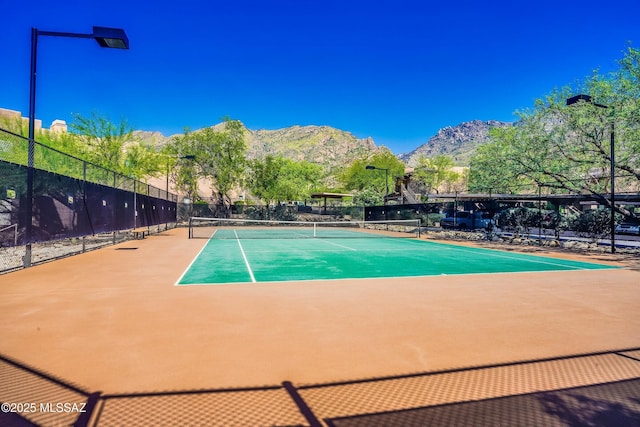 view of tennis court featuring a mountain view