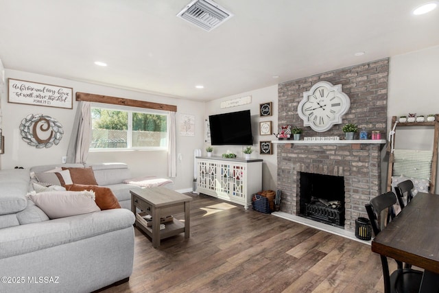 living room featuring a brick fireplace and hardwood / wood-style floors