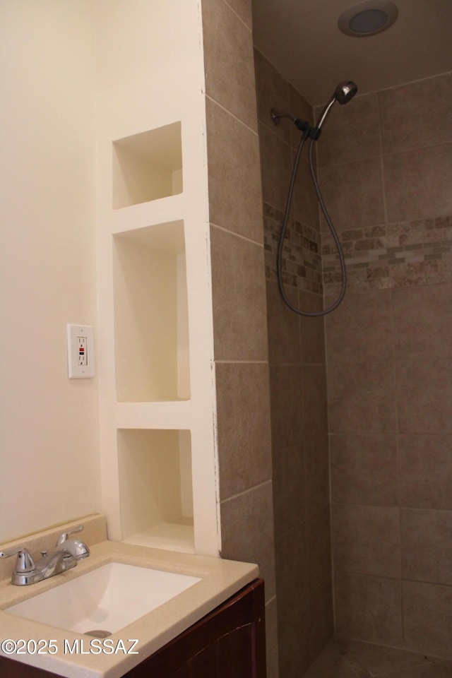 bathroom with vanity and a tile shower