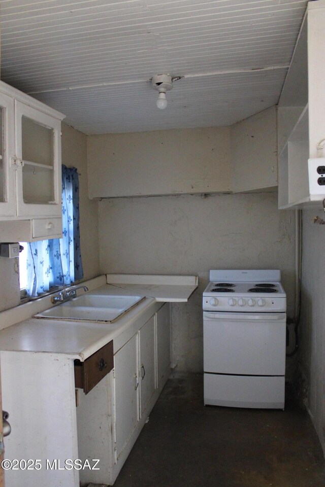 kitchen with electric stove, white cabinetry, and sink