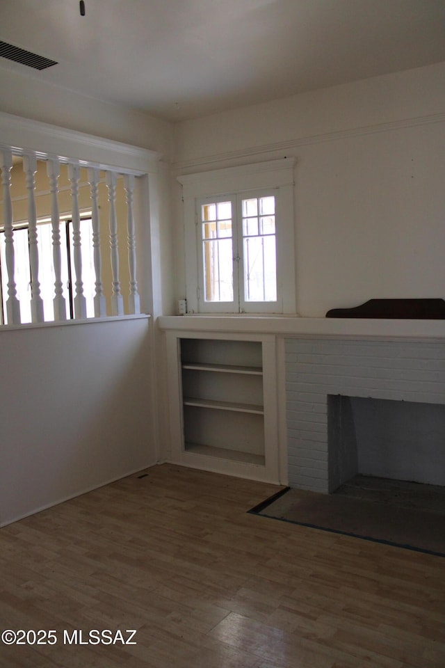 unfurnished room with hardwood / wood-style flooring and a fireplace