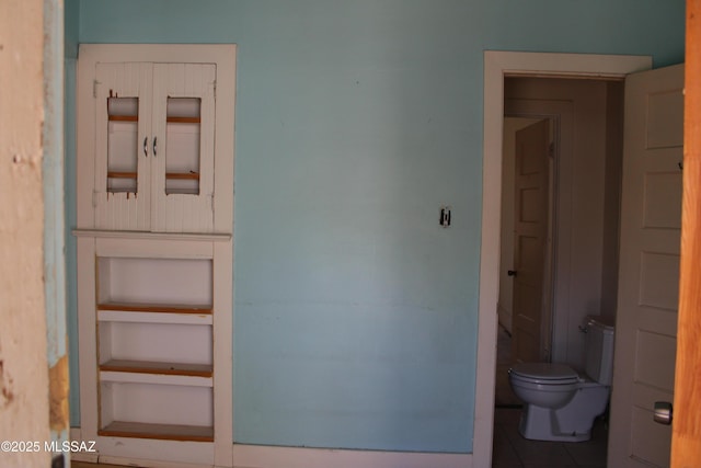 bathroom with toilet and tile patterned flooring