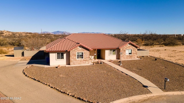 mediterranean / spanish-style home featuring a shed, a mountain view, and a patio area