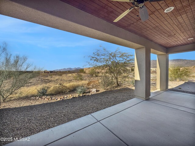 view of patio / terrace with ceiling fan and a mountain view