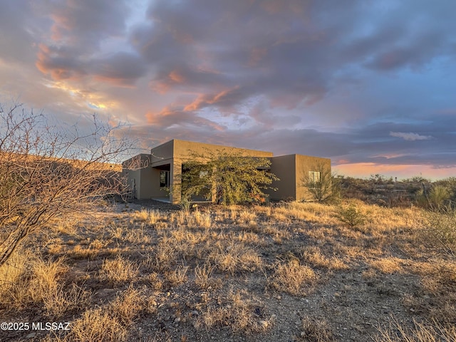 property exterior at dusk with stucco siding