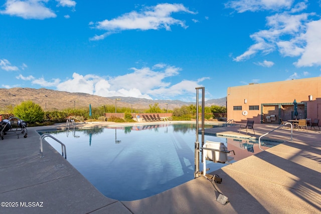 community pool with a patio area and a mountain view