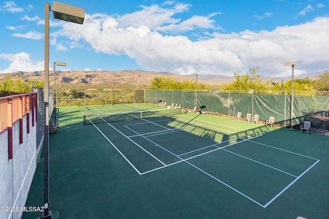 view of sport court featuring fence and a mountain view