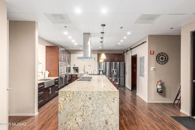 kitchen with island range hood, dark wood-style flooring, stainless steel appliances, and a sink