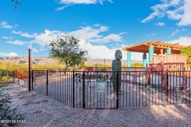 view of gate with fence and a mountain view