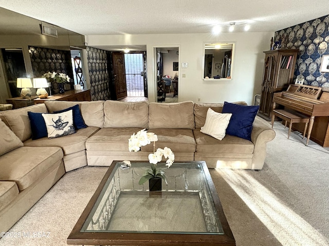 living area featuring visible vents, a textured ceiling, and carpet