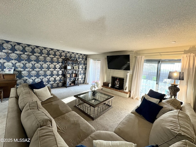 living room featuring wallpapered walls, carpet flooring, a fireplace, and a textured ceiling